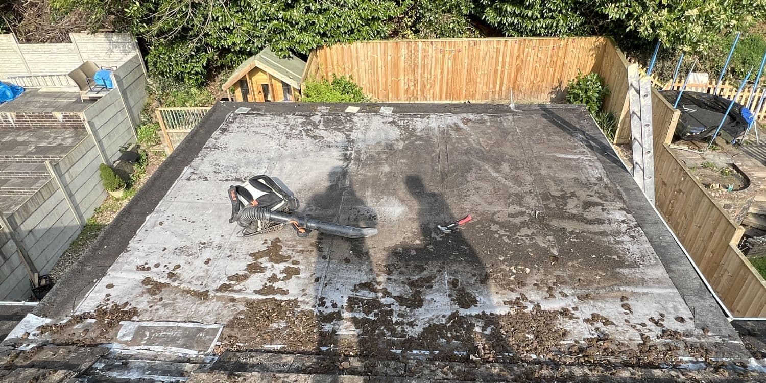 Worn, patched flat roof before the work